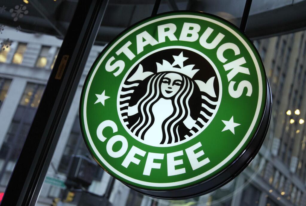 FILE - This Dec. 20, 2010 file photo shows signage at a Starbucks store in New York. (AP Photo/Richard Drew, File)