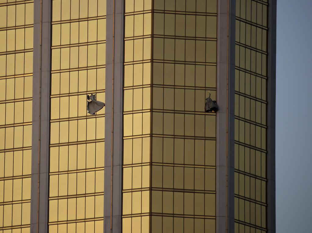 FILE - In this Monday, Oct. 2, 2017 file photo, drapes billow out of broken windows at the Mandalay Bay resort and casino on the Las Vegas Strip, following a mass shooting at a music festival in Las Vegas. (AP Photo/John Locher, File)