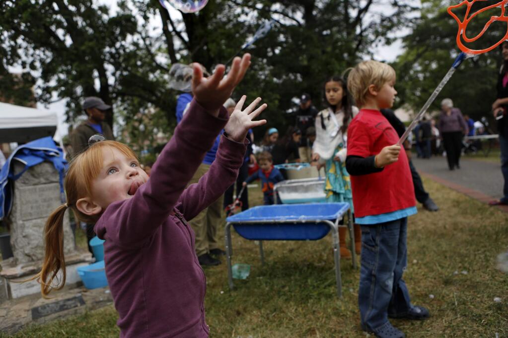 Sierra Whitebear,2, reaches for a bubble the SRJC Children's Center booth during the Larry Bertolini Day Under the Oaks event at Santa Rosa Junior College in Santa Rosa, California on Sunday, May 5, 2013. (BETH SCHLANKER/ The Press Democrat)