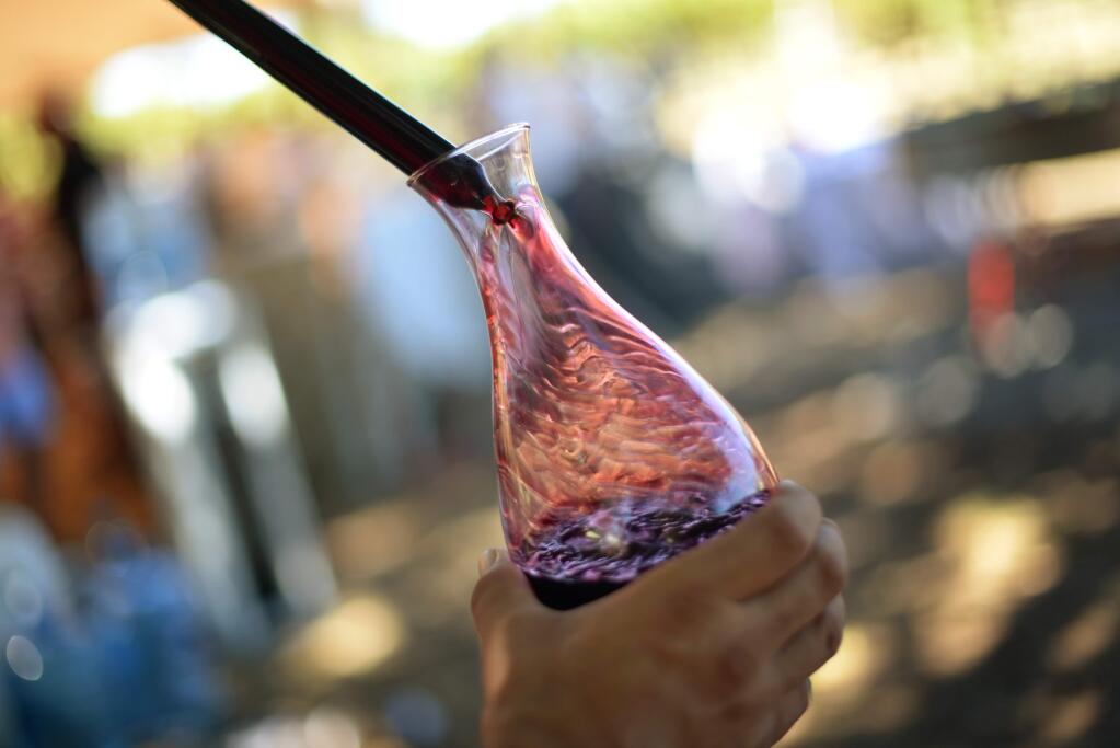Pedro Rusk with Jackson Family Wines pouring into a carafe after thiefing a barrel of 2014 Alden Park Cabernet from Alexander Valley at the 20th Annual Kendall-Jackson Heirloom Tomato Festival held at the Kendall-Jackson Wine Estate & Gardens in Fulton, California. September 24, 2016. (Photo: Erik Castro/for The Press Democrat)