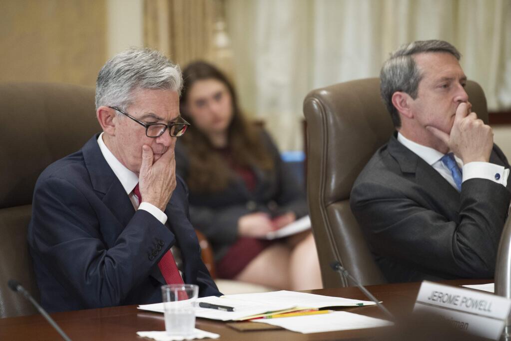 FILE- In this June 14, 2018, file photo, Federal Reserve Board Chairman Jerome Powell, left, and Vice Chair Randal Quarles listen during an open meeting in Washington. The Federal Reserve says that all of the 35 largest U.S. banks are fortified enough to survive an economic shock and keep on lending. (AP Photo/Cliff Owen, File)