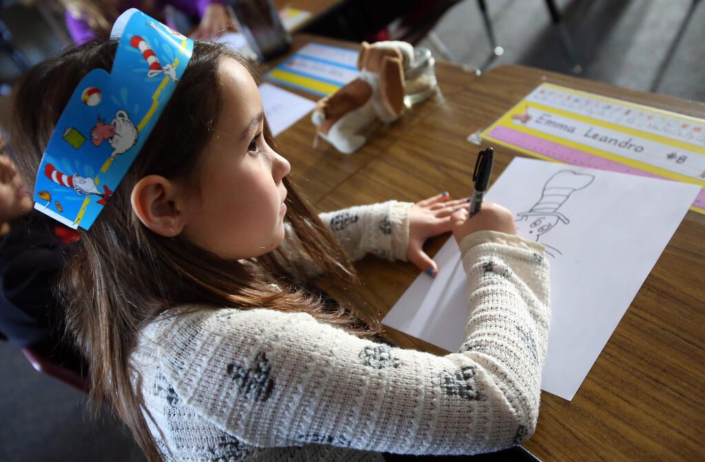 First-grader Emma Leandro works on drawing Dr. Seuss' 'The Cat in The Hat' during Read Across America at Mattie Washburn elementary school, in Windsor on Monday, March 2, 2015. (Christopher Chung/ The Press Democrat)