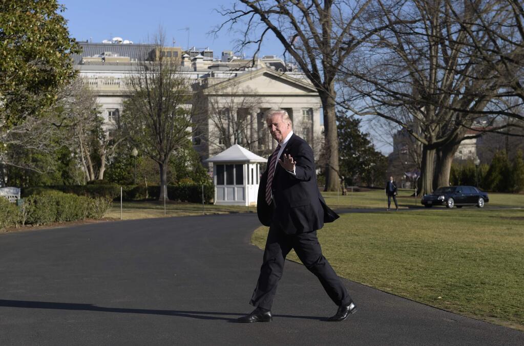President Donald Trump waves as he walks from the South Lawn of the White House in Washington, Thursday, Jan. 26, 2017, after returning from Philadelphia. (AP Photo/Susan Walsh)