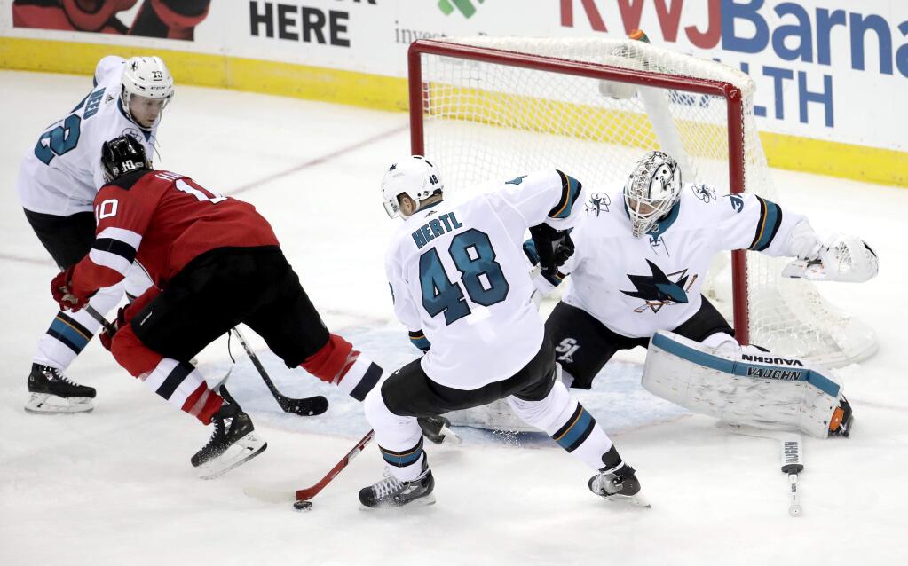 San Jose Sharks center Tomas Hertl (48), of the Czech Republic, controls the puck after New Jersey Devils right wing Jimmy Hayes (10) was unable to make a move on goalie Martin Jones (31), who lost his stick during the play, during the third period of an NHL hockey game, Friday, Oct. 20, 2017, in Newark, N.J. The Sharks won 3-0. (AP Photo/Julio Cortez)
