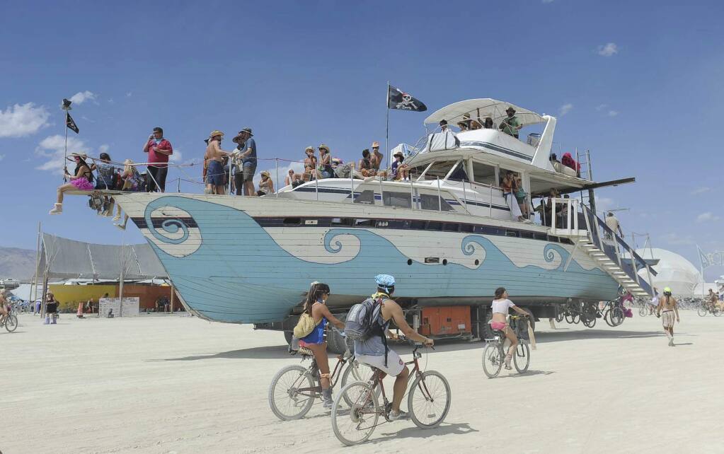 FILE - In this Aug. 31, 2012, file photo, an old wooden yacht art car rolls through the playa at Burning Man on the Black Rock Desert near Gerlach, Nev. (Andy Barron/The Reno Gazette-Journal via AP, File)