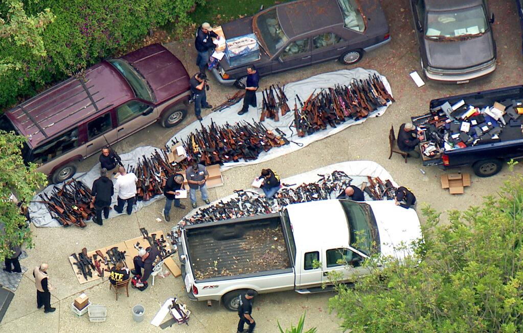 This photo from video provided by KCBS/KCAL-TV shows investigators from the U.S. Bureau of Alcohol, Tobacco, Firearms and Explosives and the police inspecting a large cache of weapons seized at a home in the affluent Holmby Hills area of Los Angeles Wednesday, May 8, 2019. Authorities seized more than a thousand guns from the home after getting an anonymous tip regarding illegal firearms sales in a posh area near the Playboy Mansion and served a search warrant around 4 a.m. Wednesday at the property on the border of the Bel Air and Holmby Hills neighborhoods. (KCBS/KCAL-TV via AP)