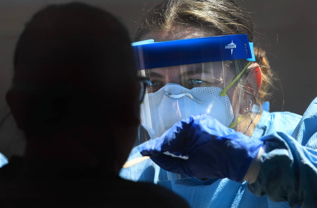 Sonoma County Public Health nurse Katy Jenkins prepares to swab a Sonoma County resident as part of the coronavirus tracing program, Wednesday, April 22, 2020 in Santa Rosa. (Kent Porter / The Press Democrat) 2020