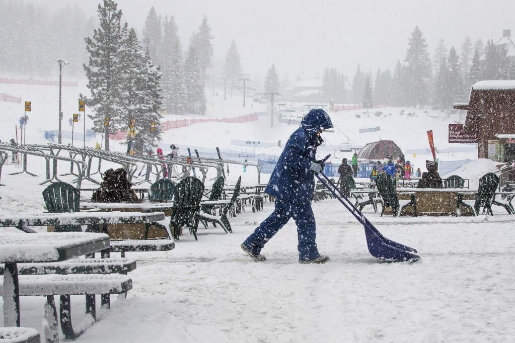 In this photo provided by Northstar California Resort, an employee clears away snow after the resort received more than a foot in 24 hours Wednesday, Jan. 6, 2016, in Truckee, Calif. The latest storm to hit the Sierra dropped a foot of snow on ski resorts around Lake Tahoe on Wednesday, with a couple of inches in the valleys and freezing fog that caused dozens of crashes on slippery roads. (Northstar California Resort via AP)