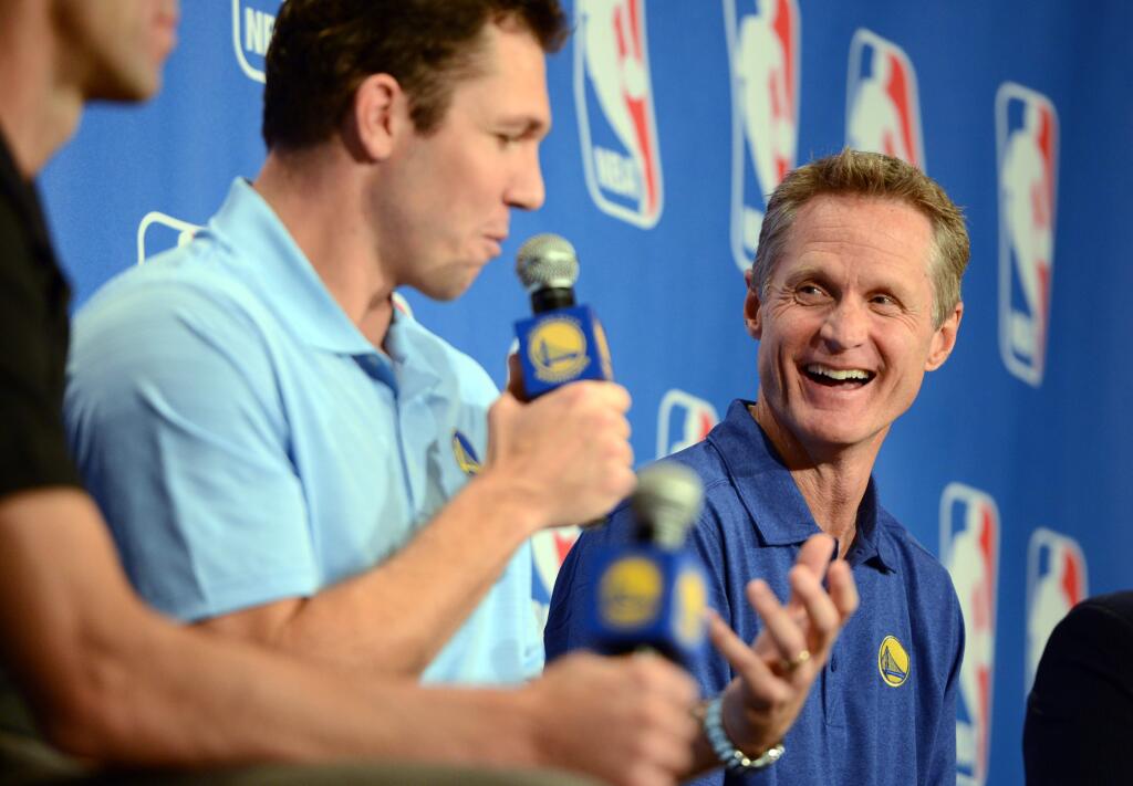 Golden State Warriors head coach Steve Kerr, right, listens as assistant coach Luke Walton addresses the media after Kerr was named the NBA coach of the year, Tuesday, April 26, 2016, in Oakland, Calif. Kerr won the award after leading to the Golden State Warriors to the best regular season record in league history. Kerr got 64 first-place votes from the panel of 130 media members who regularly cover the league. Portland's Terry Stotts was second in relatively close voting. San Antonio's Gregg Popovich was third. (Kristopher Skinner/Oakland Tribune via AP)