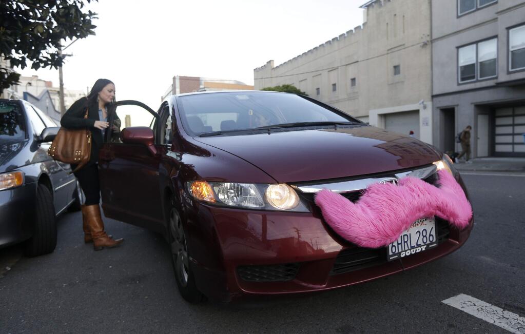 FILE - In this Jan. 4, 2013 file photo, Lyft passenger Christina Shatzen gets into a car driven by Nancy Tcheou, in San Francisco. One of the new laws taking effect in California July 1 will require drivers for ride-sharing companies, such as Uber and Lyft, to carry a minimum level of insurance.(AP Photo/Jeff Chiu, File)