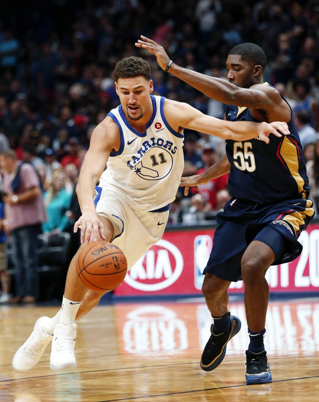 Golden State Warriors guard Klay Thompson, left, drives against New Orleans Pelicans guard E'Twaun Moore in the first half in New Orleans, Friday, Oct. 20, 2017. (AP Photo/Gerald Herbert)