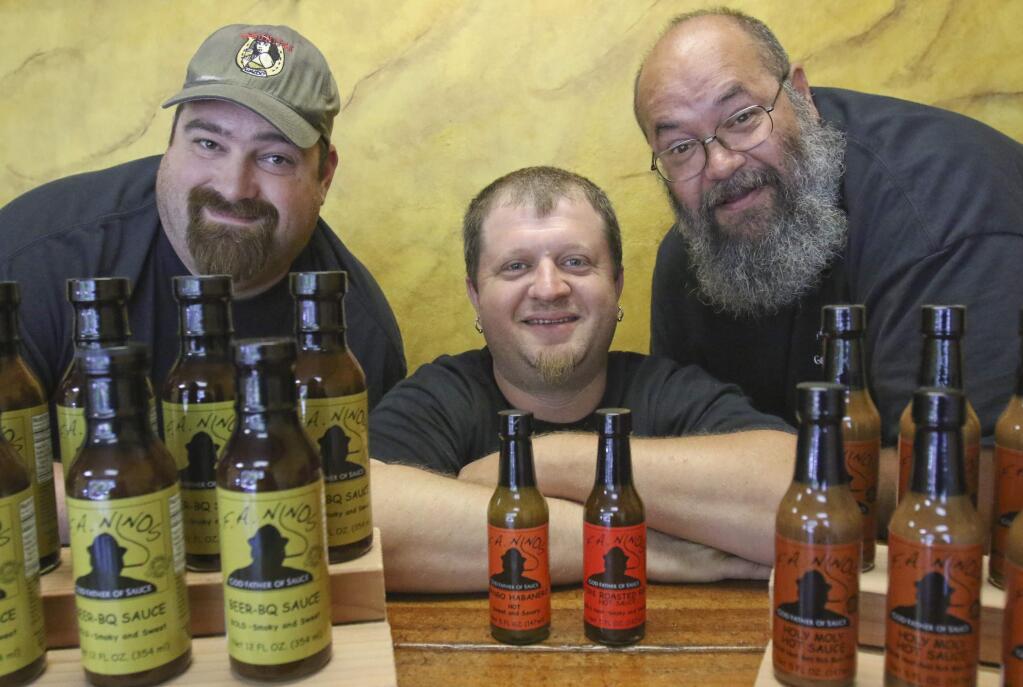 From left, Ryan Rommel, Chuck Ross, and Frank Ross with some of their line of BBQ sauces, hot sauces, and dry rubs they make under the F.A. Nino's label at their tasting room on Industrial Ave. in Petaluma on Monday, June 15, 2015. (SCOTT MANCHESTER/ARGUS-COURIER STAFF)