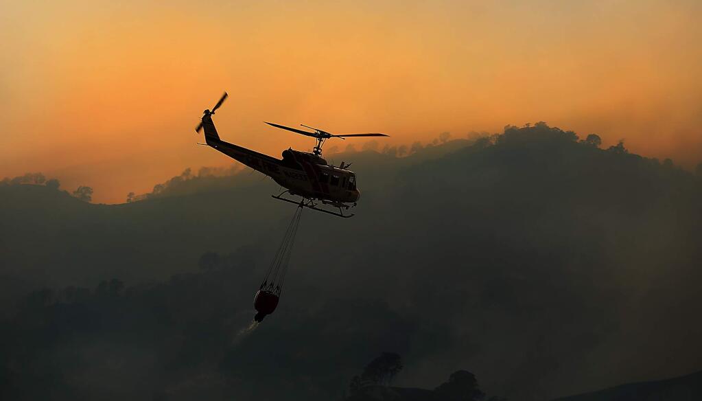 A Cal Fire helicopter heads to the Cold fire near Lake Berryessa, Tuesday, Aug. 2, 2016. (KENT PORTER/ PD)