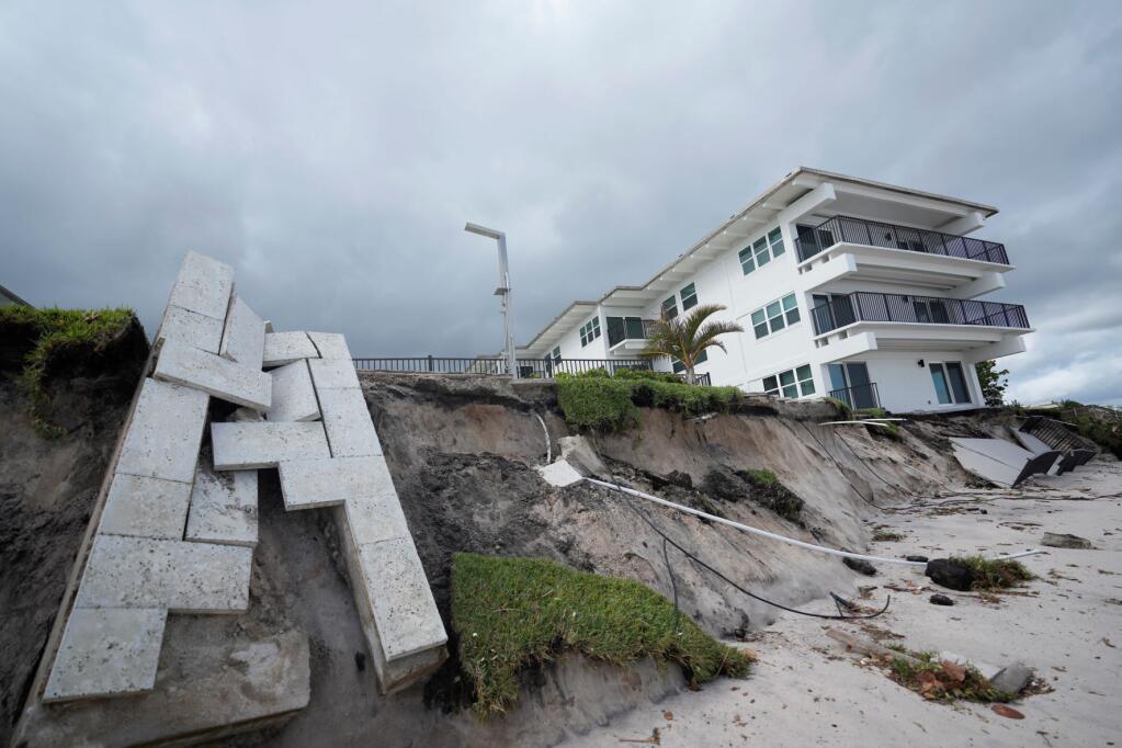 Condominium amenities and a unit terrace lie toppled onto the beach after the sand below was swept away, following the passage of Hurricane Nicole, Thursday, Nov. 10, 2022, at Ocean Club Condominiums in Vero Beach, Fla. (AP Photo/Rebecca Blackwell)