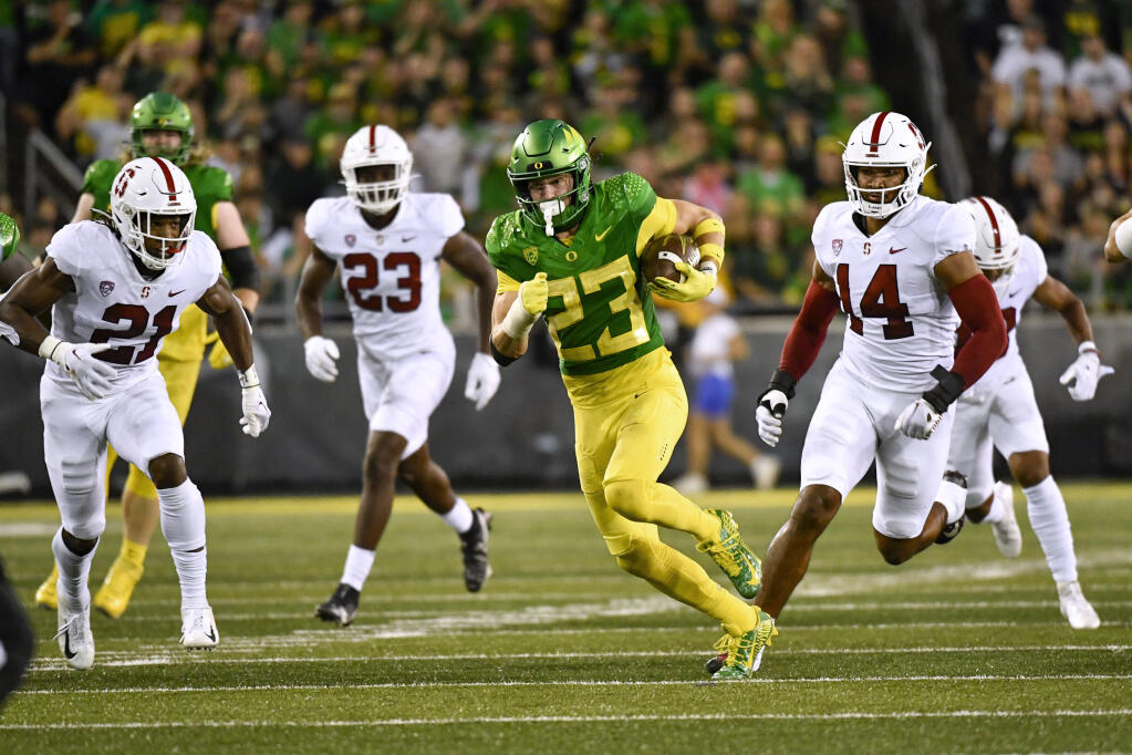 Oregon wide receiver Chase Cota (23) is chased by Stanford safety Kendall Williamson (21), defensive end David Bailey (23) and linebacker Jacob Mangum-Farrar (14) during the first half Oct. 1, 2022, in Eugene, Ore. (AP Photo/Andy Nelson)