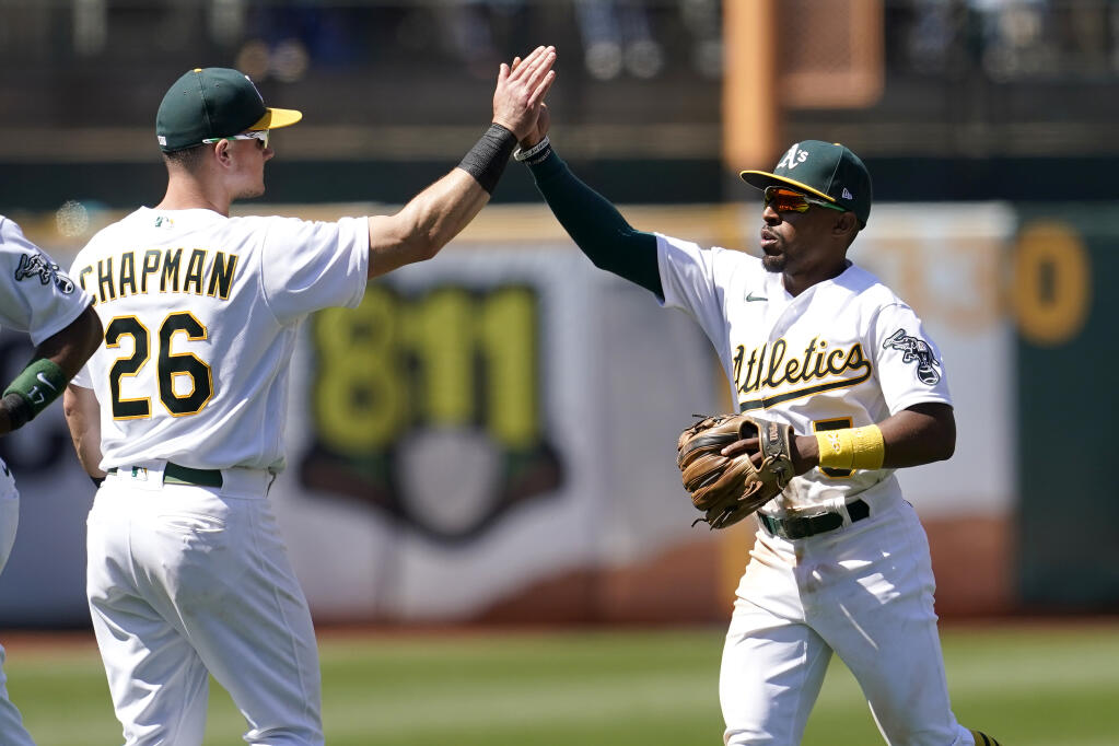 The Oakland Athletics’ Matt Chapman, left, celebrates with Tony Kemp after defeating the Los Angeles Angels on Tuesday, July 20, 2021. (Jeff Chiu / ASSOCIATED PRESS)