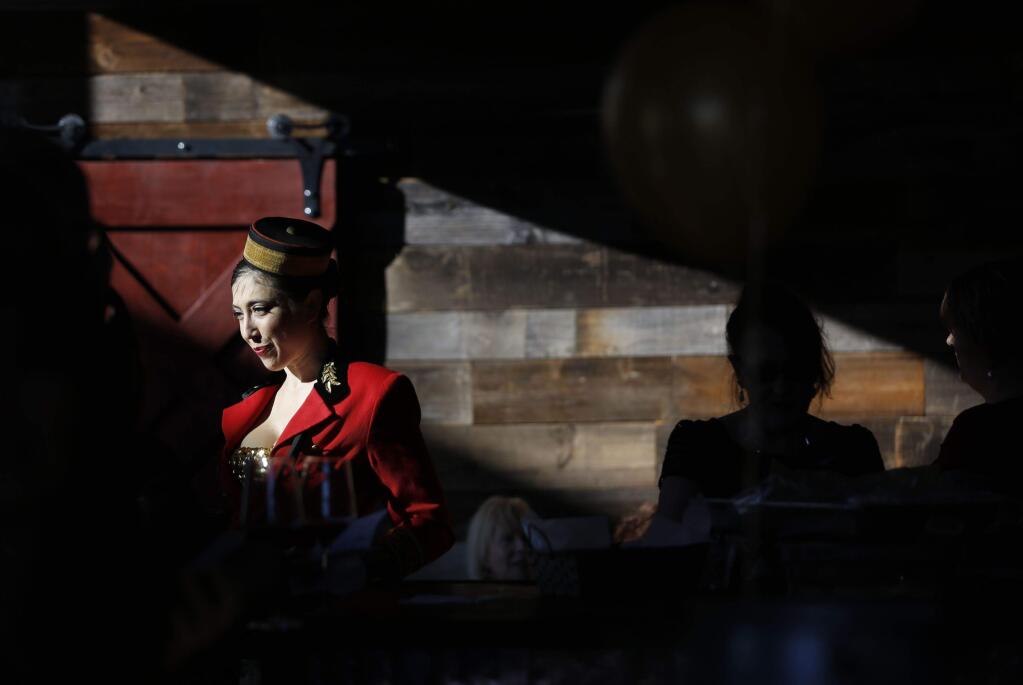 Volunteer Misti Harris, dressed as a cigarette girl, sells raffle tickets during an Oscar party fundraiser for Food For Thought at Wind Gap tasting room on Sunday, February 22, 2015 in Sebastopol, California . (BETH SCHLANKER/ The Press Democrat)