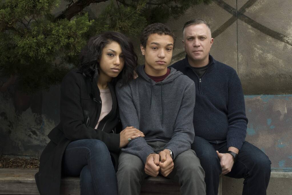 Former Analy High student Evan Mack, 16, center, with parents Raquel and John Mack photographed at Analy High School near the entrance of the school's library in Sebastopol. The family is going public because they feel Analy High School administrators have not held students of racist attacks against their son accountable for their actions. January 24, 2016. (Photo: Erik Castro/for The Press Democrat)