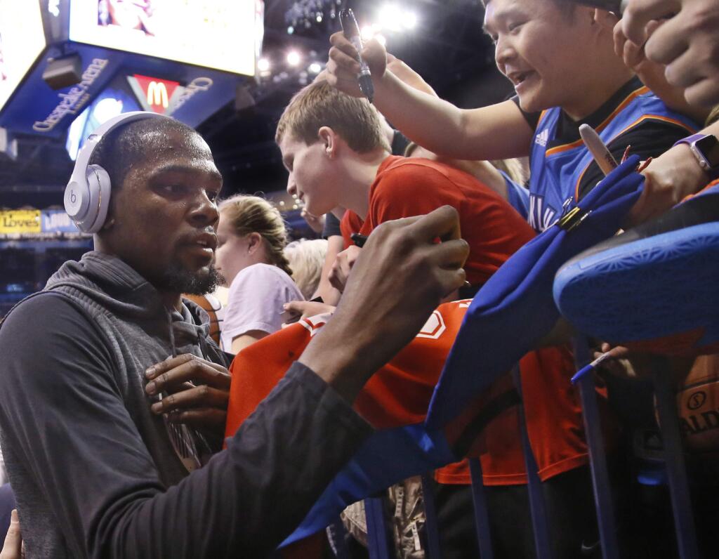 Golden State Warriors forward Kevin Durant gives autographs to fans before an NBA basketball game against the Oklahoma City Thunder in Oklahoma City, Saturday, Feb. 11, 2017. (AP Photo/Sue Ogrocki)