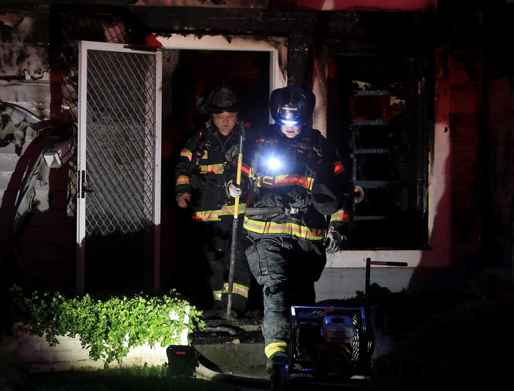 Santa Rosa firefighters exit a home on East Foothill Drive after a fire apparently caused by a hoverboard. (KENT PORTER / The Press Democrat)