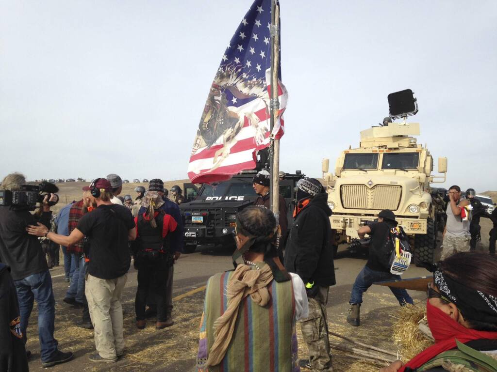 Dakota Access pipeline protesters defy law enforcement officers who are trying to force them from a camp on private land in the path of pipeline construction on Thursday, Oct. 27, 2016, near Cannon Ball, N.D. The months-long dispute over the four-state, $3.8 billion pipeline reached a crisis point when the protesters set up camp on land owned by pipeline developer Energy Transfer Partners. The disputed area is just to the north of a more permanent and larger encampment on federally-owned land where hundreds of protesters have camped for months. (AP Photo/James MacPherson)