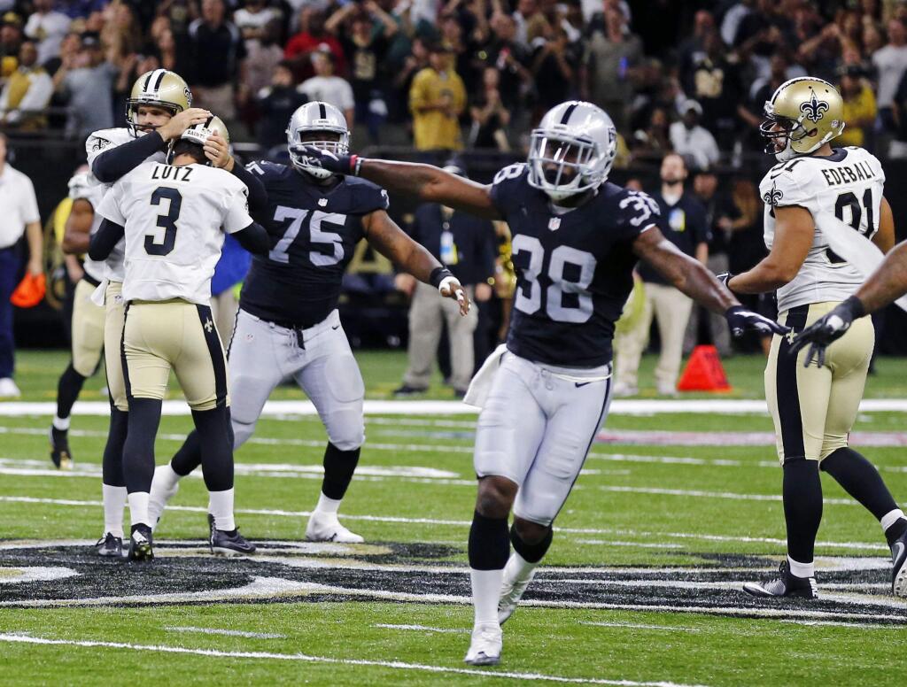 New Orleans Saints kicker Wil Lutz (3) reacts with holder Thomas Morstead as Oakland Raiders defensive tackle Darius Latham (75), linebacker Bruce Irvin (51) and strong safety T.J. Carrie (38) celebrate, after Lutz missed a field goal. (AP Photo/Butch Dill)