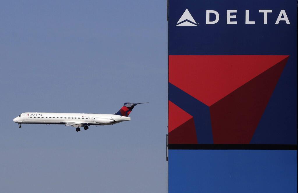 FILE - In this Saturday, April 6, 2013 file photo, a Delta Airlines jet flies past the company's billboard at Citi Field, in New York. Delta says Thursday, Feb. 16, 2017 that it will start serving meals to all passengers on 12 long-haul routes over the next several weeks. Airlines took away free sandwiches and similar fare after an industry downturn during the worldwide financial crisis. (AP Photo/Mark Lennihan)