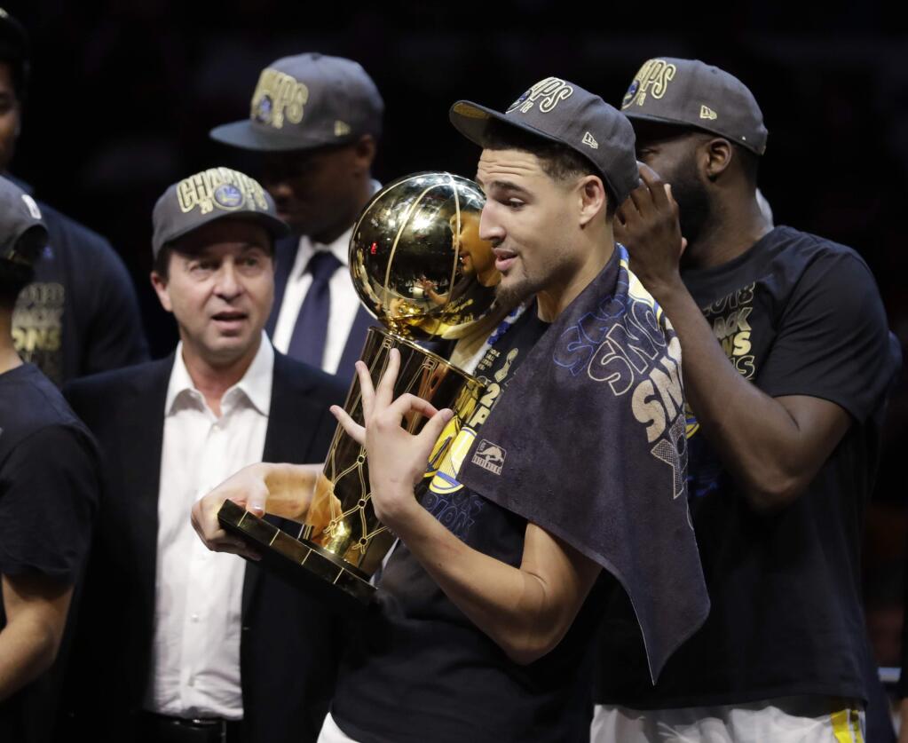 The Golden State Warriors' Klay Thompson gestures while holding the trophy after the Warriors defeated the Cleveland Cavaliers 108-85 in Game 4 of the NBA Finals to win the NBA championship, Friday, June 8, 2018, in Cleveland. (AP Photo/Tony Dejak)
