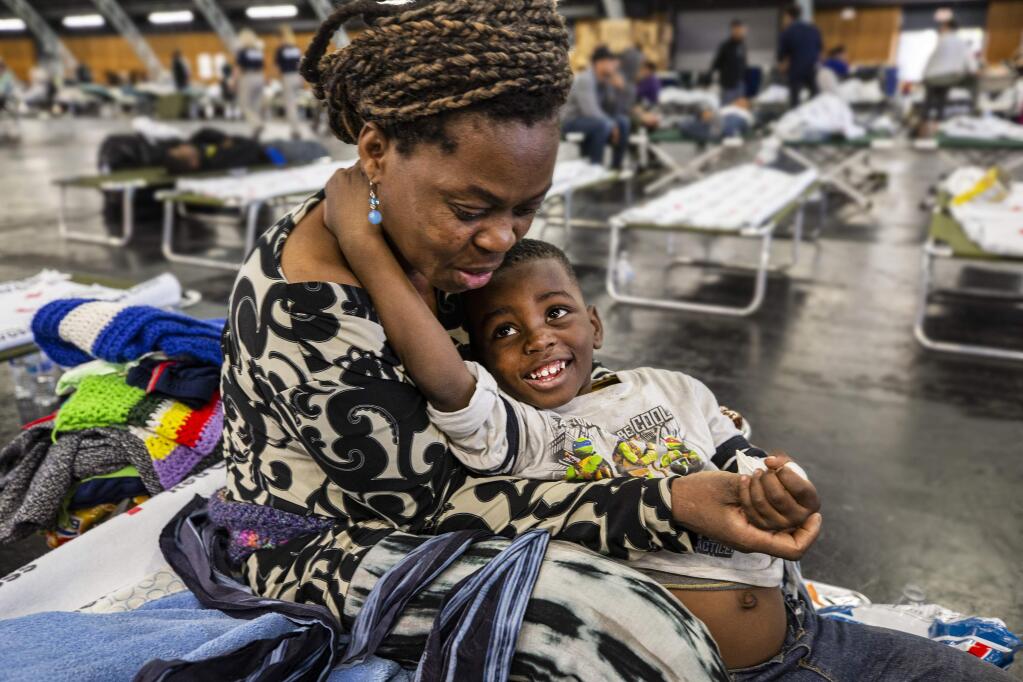 Bernadette Yabadi and her son Victor evacuated their Santa Rosa home to the Red Cross shelter at the Sonoma County Fairgrounds after officials expanded evacuation orders Sunday morning after heavy winds pushed the Kincade fire to the south. (photo by John Burgess/The Press Democrat)