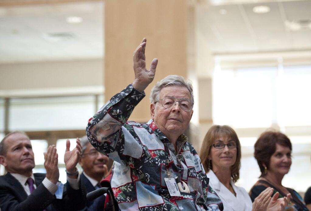 In this undated photo, Medtronic founder Earl Bakken waves as he's acknowledged by new CEO Omar Ishrak at the annual shareholders meeting at Medtronic's Fridley, Minn., headquarters. Medtronic said in a statement that co-founder Bakken died Sunday, Oct. 21, 2018, at his home in Hawaii. (Glen Stubbe/Star Tribune via AP)