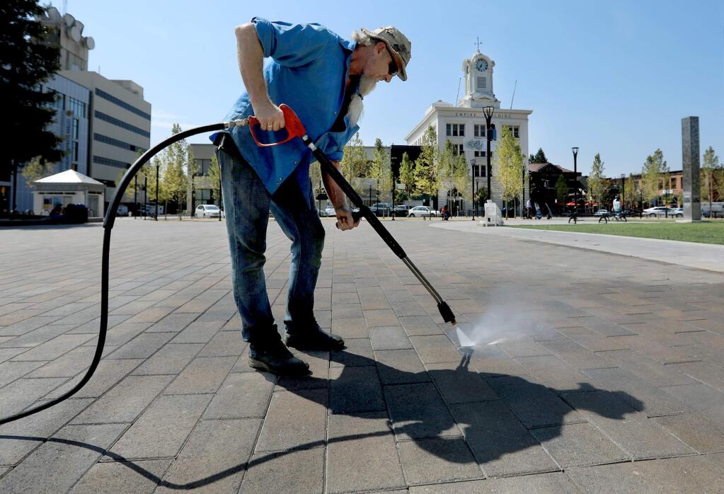 Burt Schuldts of S & B SodaBlast, pressure washes Old Courthouse Square in Santa Rosa, Wednesday Sept. 6, 2017. (Kent Porter / The Press Democrat) 2017