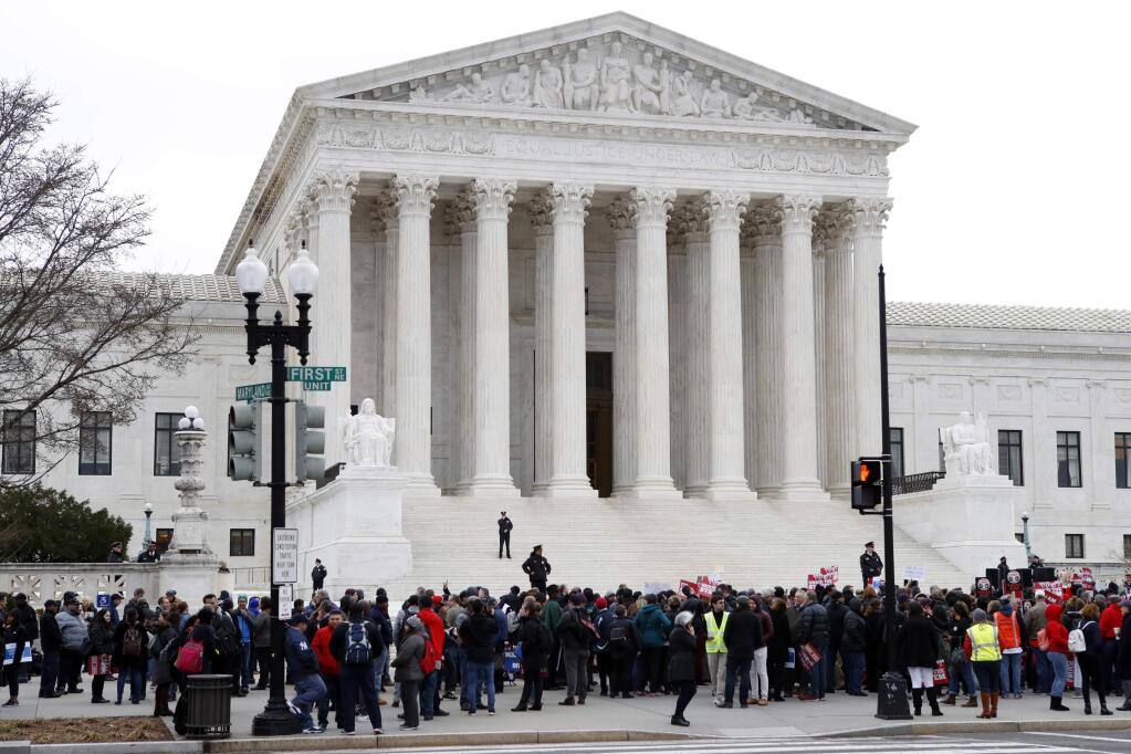 People rally outside of the Supreme Court, Monday, Feb. 26, 2018, in Washington. (AP Photo/Jacquelyn Martin)