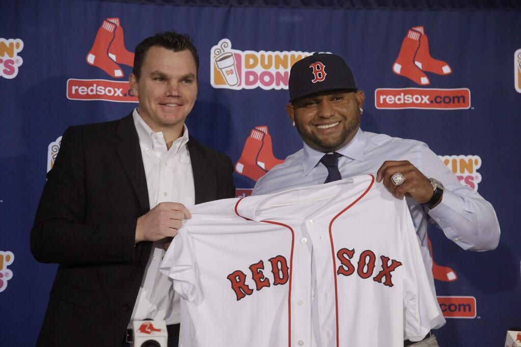 Newly acquired Boston Red Sox free agent third baseman Pablo Sandoval smilies as he and Red Sox general manager Ben Cherington pose with a team jersey as Sandoval is introduced to the media at Fenway Park Tuesday, Nov. 25, 2014 in Boston. (AP Photo/Stephan Savoia)