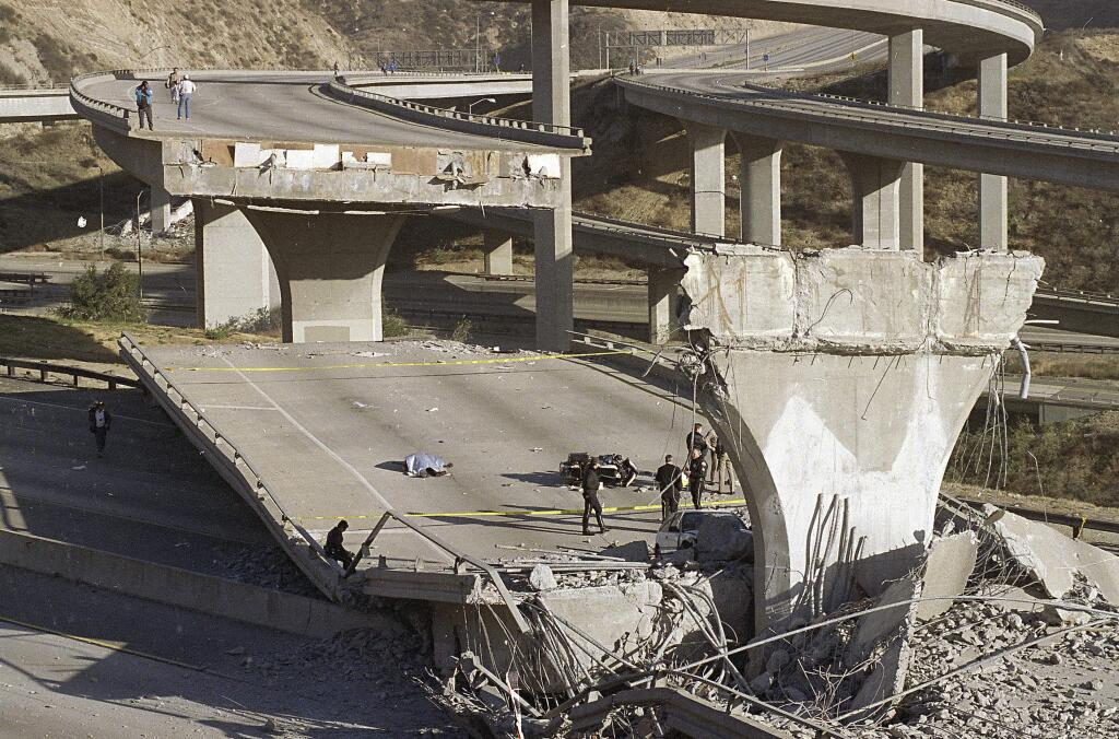 FILE - In this Jan. 17, 1994, file photo, the covered body of Los Angeles Police Officer Clarence Wayne Dean, 46, lies near his motorcycle which plunged off the State Highway 14 overpass that collapsed onto Interstate 5, after a magnitude-6.7 Northridge earthquake in Los Angeles. A new study says an earthquake fault running from San Diego to Los Angeles is capable of producing a magnitude-7.4 temblor that could affect some of the most densely populated areas in California. (AP Photo/Doug Pizac, File)