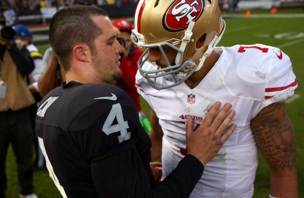 Raiders quarterback Derek Carr meets with 49ers quarterback Colin Kaepernick after the teams' meeting in December at O.co Coliseum. (Christopher Chung / The Press Democrat)