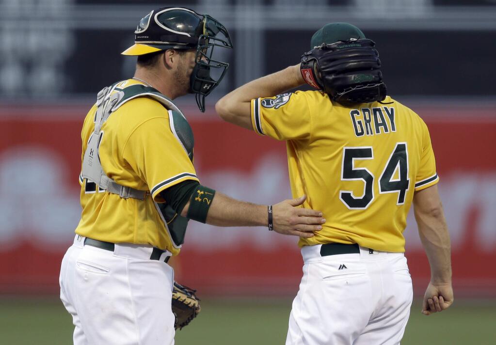 Oakland Athletics catcher Stephen Vogt, left, speaks with pitcher Sonny Gray (54) during the first inning of a baseball game against the Houston Astros on Tuesday, June 20, 2017, in Oakland, Calif. (AP Photo/Ben Margot)