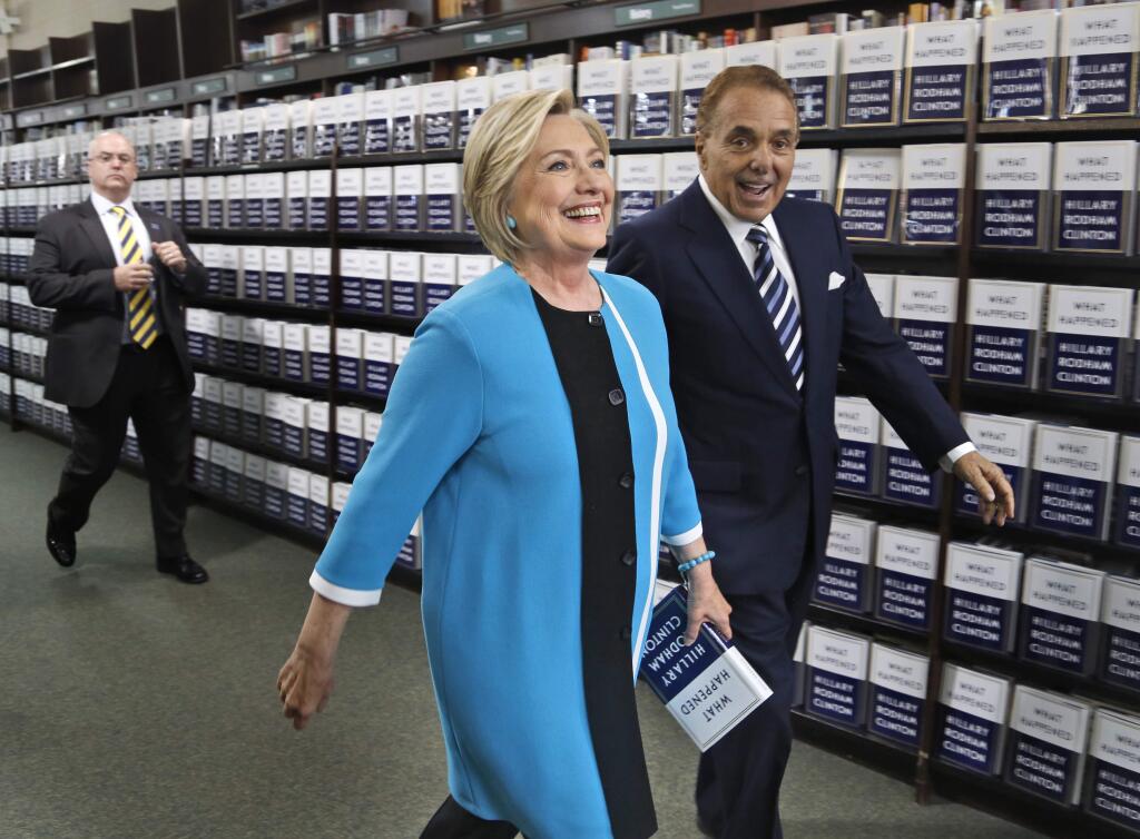 Hillary Rodham Clinton, escorted by Leonard Riggio, chairman of Barnes and Noble, arrives to sign copies of her book 'What Happened' at a book store in New York, Tuesday, Sept. 12, 2017. (AP Photo/Seth Wenig)