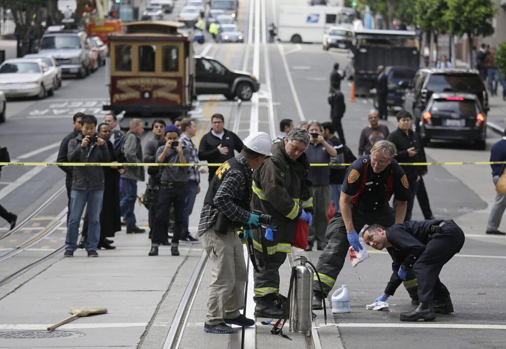 San Francisco firemen clean California Street after window washer 58-year-old Pedro Perez fell 11 stories onto a moving car Friday, Nov. 21, 2014, in San Francisco. (AP Photo/Eric Risberg)