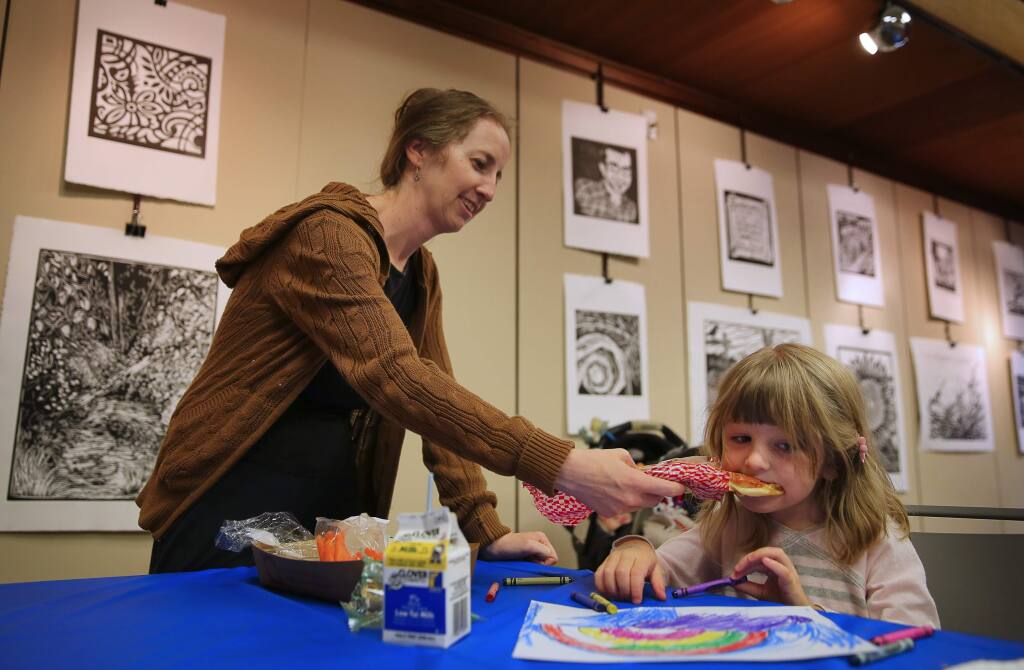 Kathleen Lennon, feeds her 4-year-old daughter, Ana, a slice of cheese pizza at the Free Summer Lunch Program, which is part of the nationwide Summer Food Service Program, at the Sebastopol Library, in Sebastopol, on Tuesday, July 5, 2016. (Christopher Chung/ The Press Democrat)