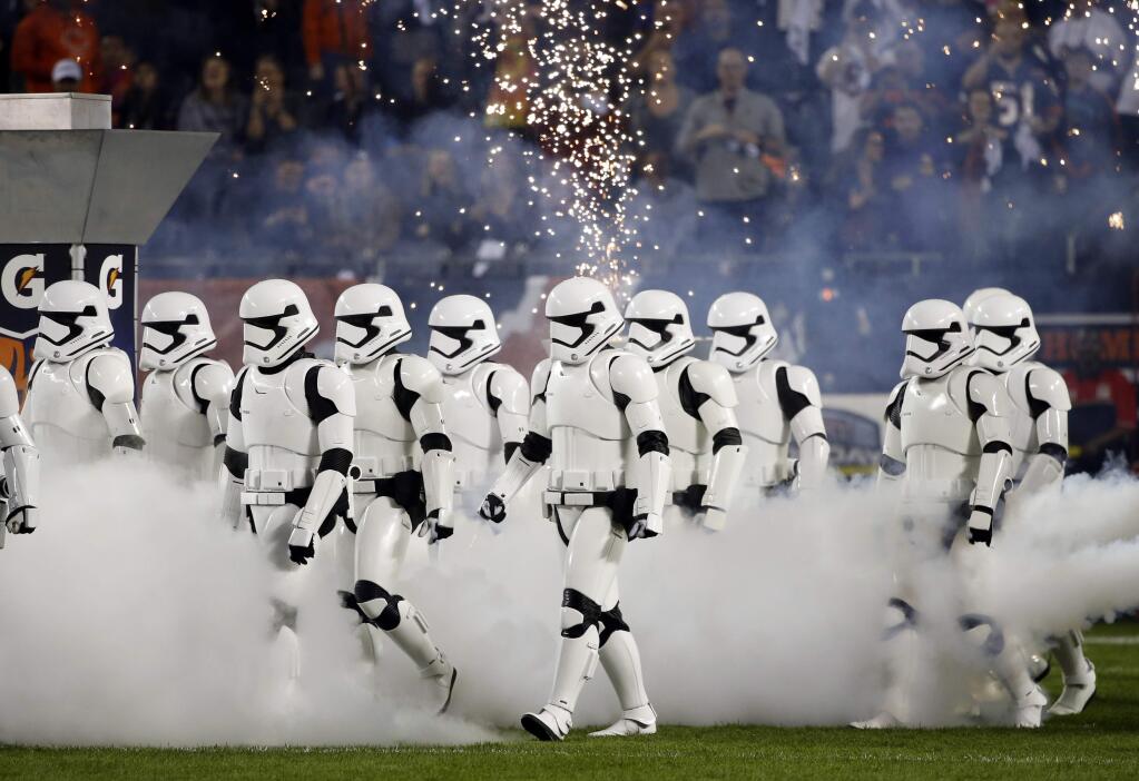 Stormtroopers march down the field during the halftime of an NFL football game between the Chicago Bears and the Minnesota Vikings, Monday, Oct. 9, 2017, in Chicago. The trailer for 'Star Wars: The Last Jedi' debuted in dramatic fashion during Monday Night Football halftime. Fireworks flashed and Stormtroopers marched onto Chicago's Soldier Field as the preview played onscreen. (AP Photo/Charles Rex Arbogast)