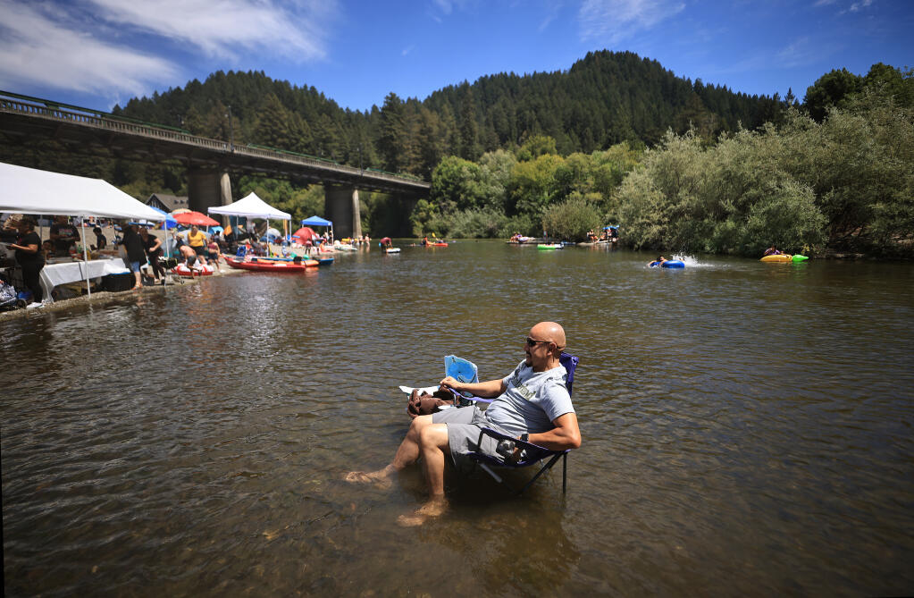 Basilio Ochoa of Oakland lounges in the seriously shallow Russian River at the Monte Rio Public Beach, Saturday, July 3, 2021 as he celebrates the Fourth of July holiday with family with friends.   (Kent Porter / The Press Democrat, 2021)