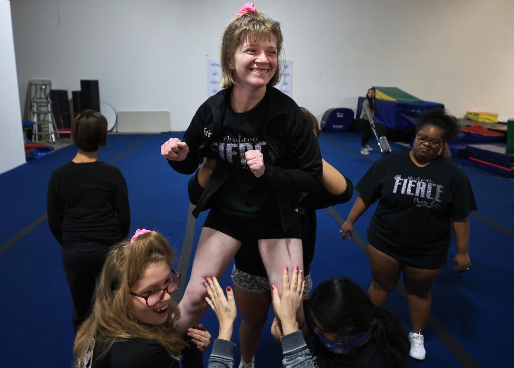 Erin Kelly, 23, celebrates with a smile after completing a pyramid with her teammates Ella Ponsford, 18, left, and Lali Salinas, 20, right. Background left is Gigi Rocha, 14, and Franchesca Felix, 22, right. The group of special needs athletes compete for Team Resilience. (Kent Porter / The Press Democrat) 2023