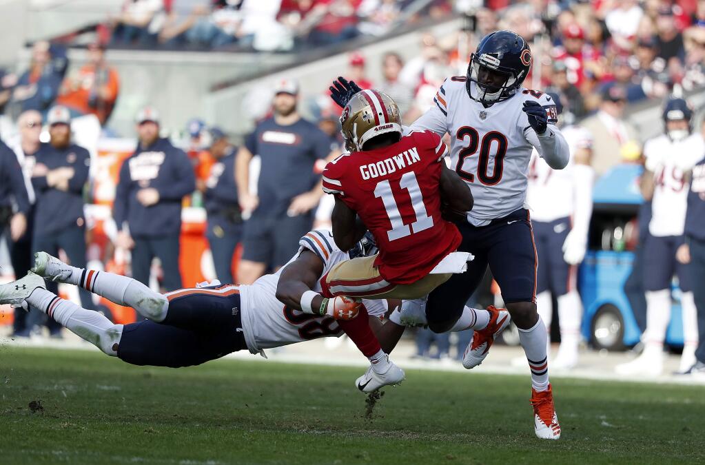 San Francisco 49ers wide receiver Marquise Goodwin (11) is tackled by Chicago Bears strong safety Adrian Amos Jr., bottom, and cornerback Prince Amukamara (20) during the first half of an NFL football game in Santa Clara, Calif., Sunday, Dec. 23, 2018. (AP Photo/Tony Avelar)