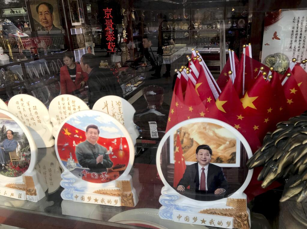 Memorabilia featuring Chinese President Xi Jinping are displayed at a souvenir shop in Beijing, Monday, Feb. 26, 2018. Chinese censors moved quickly Monday to scrub satirical commentary online about the ruling Communist Party's moves to enable Xi to stay in power indefinitely, while political observers weighed the possibility that China would return to an era of one-man rule. (AP Photo/Ng Han Guan)
