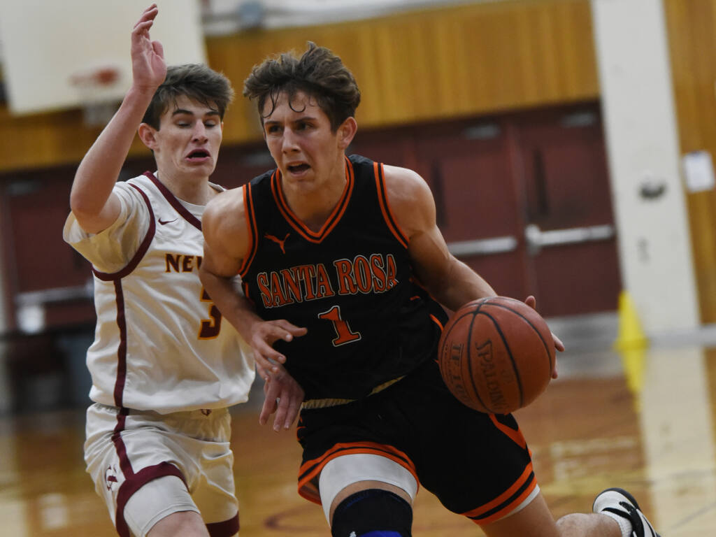 Will Logue, right, of Santa Rosa High, works his way around Sam Cline of Cardinal Newman during the Sonoma County Classic championship basketball game held at Piner High School in Santa Rosa, California, on Thursday, December 30, 2021. (Erik Castro/for The Press Democrat)