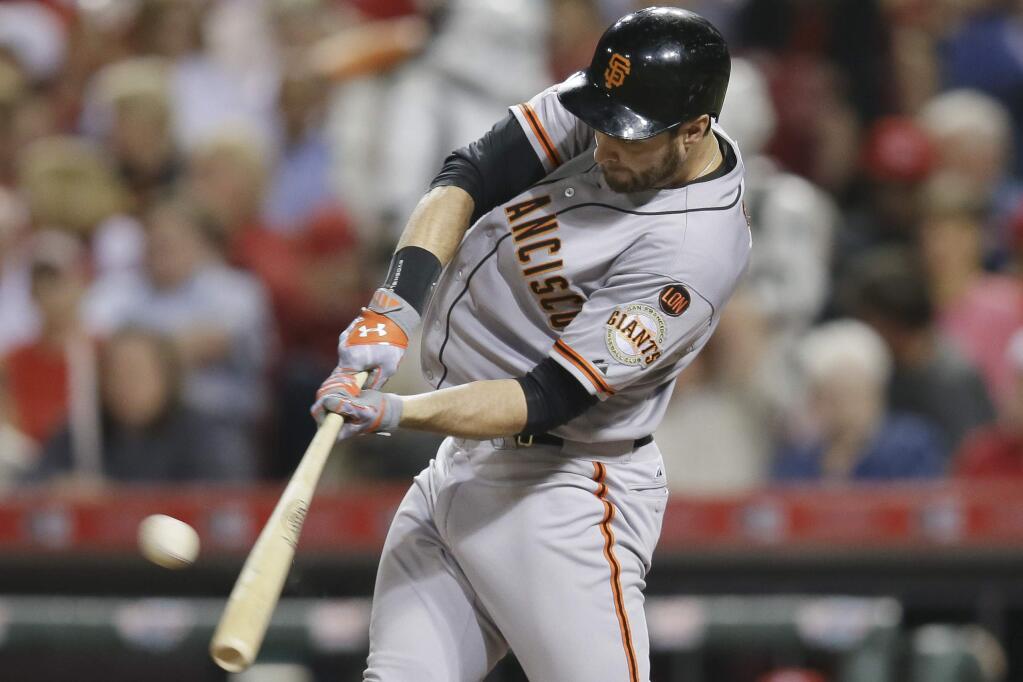 San Francisco' Giants Brandon Belt hits a double to drive home Angel Pagan in the seventh inning of a game against the Cincinnati Reds, Friday, May 15, 2015, in Cincinnati. (AP Photo/John Minchillo)