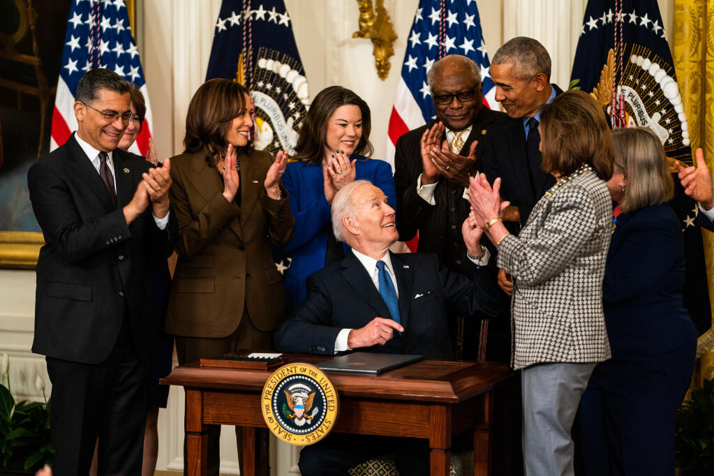 President Biden hands the pen used to sign an executive order expanding access to the Affordable Care Act to former president Barack Obama in the East Room of The White House on April 5. MUST CREDIT: Washington Post photo by Demetrius Freeman.