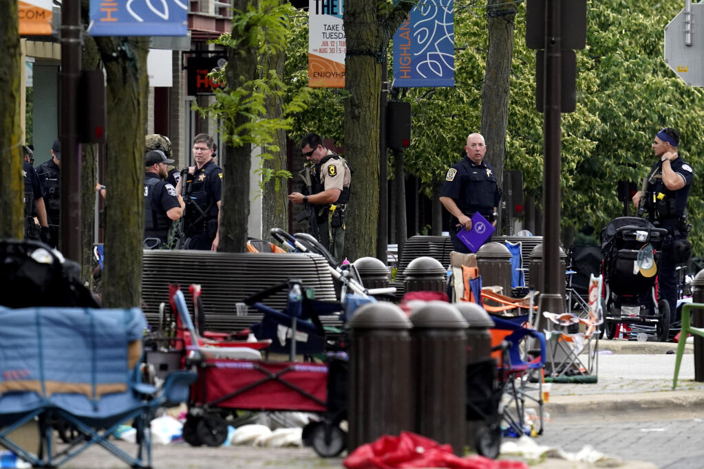 Law enforcement search after a mass shooting at the Highland Park Fourth of July parade in downtown Highland Park, Ill., on Monday, July 4, 2022. (AP Photo/Nam Y. Huh)