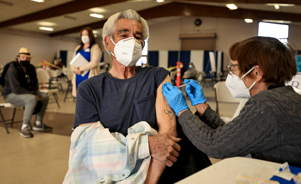 Tony Pardo, 86, of Santa Rosa, receives a booster shot by registered nurse Leah Harmon of Santa Rosa, during a COVID-19 vaccination clinic at the Sonoma County Fairgrounds, Saturday, Jan. 29, 2022. (Kent Porter / The Press Democrat) 2022