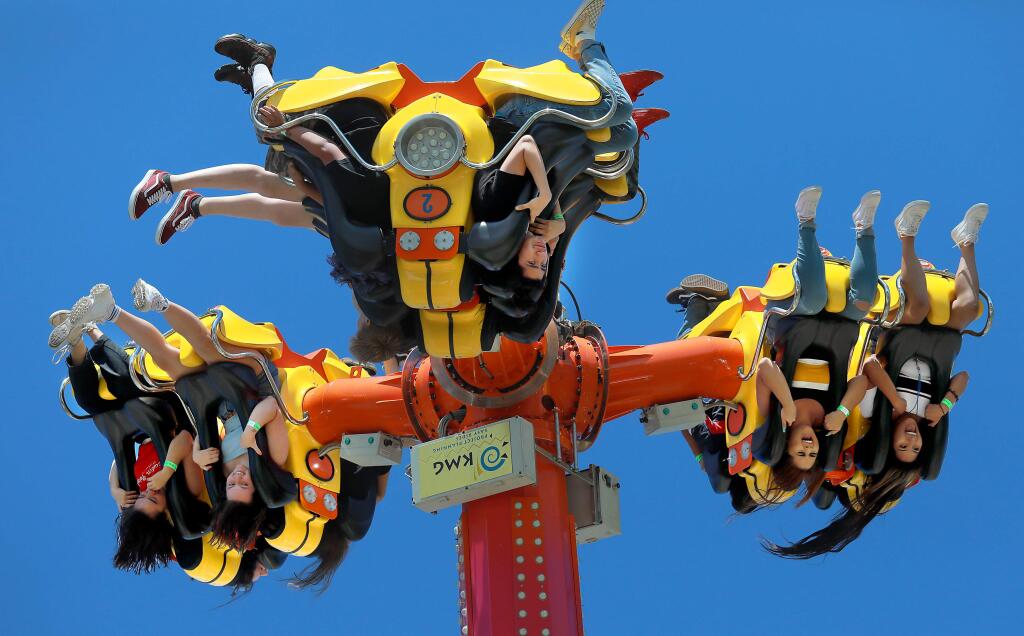 Teens scream as they turn upside down high above the midway on the Inversion ride at the opening day of the Sonoma County Fair on Friday, Aug. 2, 2018. (JOHN BURGESS/ PD)